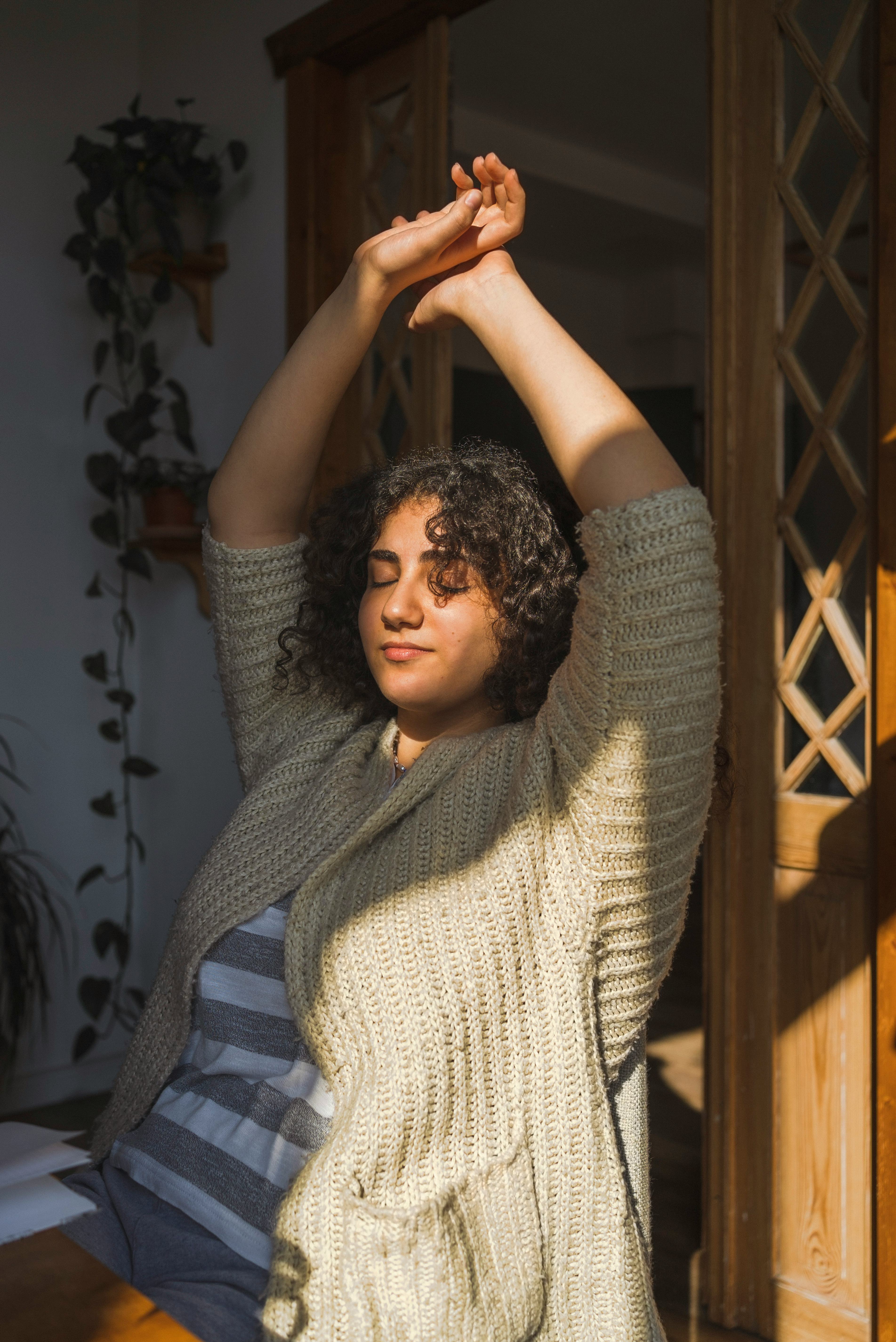 young woman stretches her arms up as she reflects on how september 2022 will affect her sign the lea...