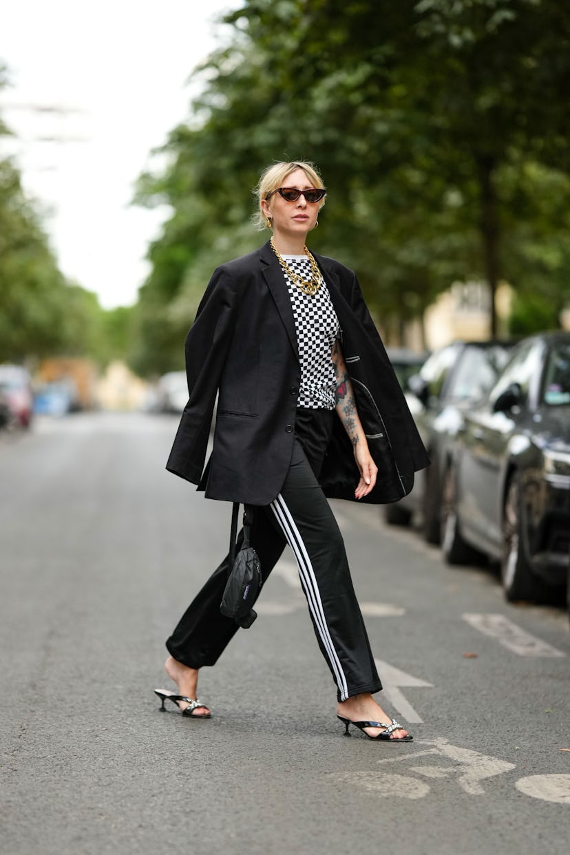 PARIS, FRANCE - JUNE 29: Emy Venturini wears black cat eyes sunglasses from Ray Ban, gold earrings, ...