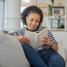 Young woman reading a book while relaxing at home