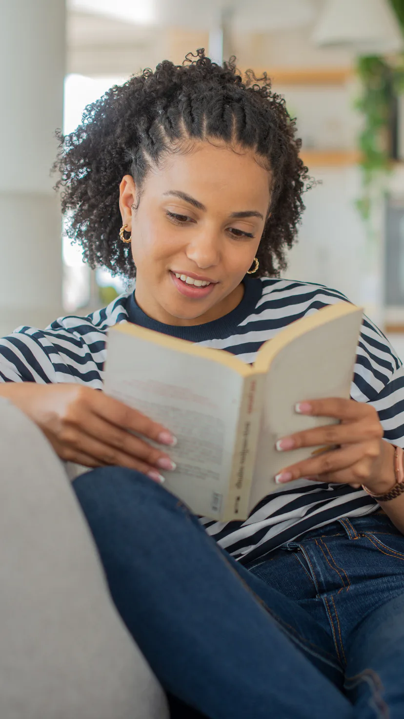 Young woman reading a book while relaxing at home
