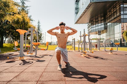 Bestes Körpergewichtstraining für Muskelaufbau 7 Ein Mann macht in einem Trainingspark Ausfallschritte im Freien.