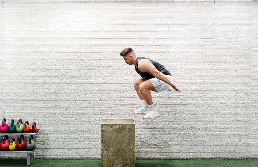A man in mid-air as he does a box jump