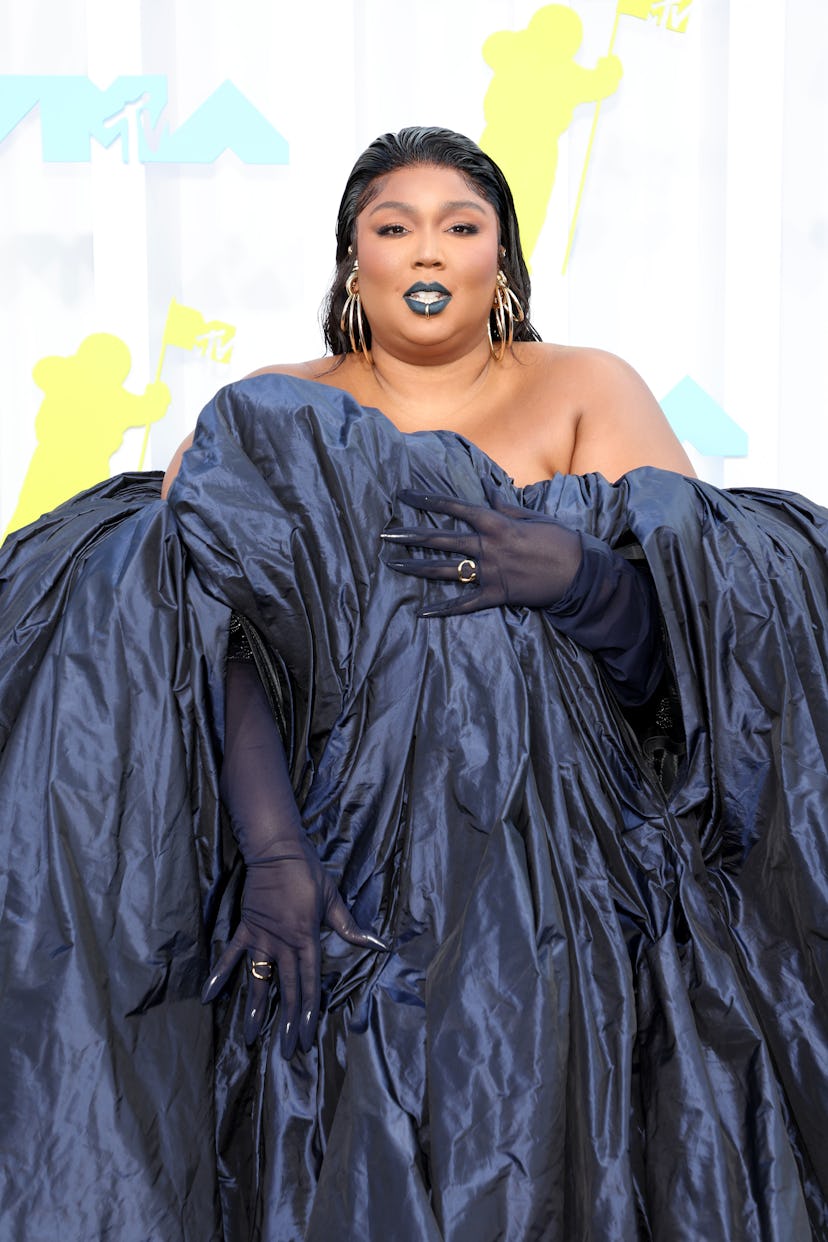 Lizzo with dark lipstick and wearing a dark blue gown at the 2022 MTV VMAs