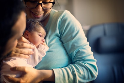 mother snuggling a newborn baby in an article about baby choking on mucus