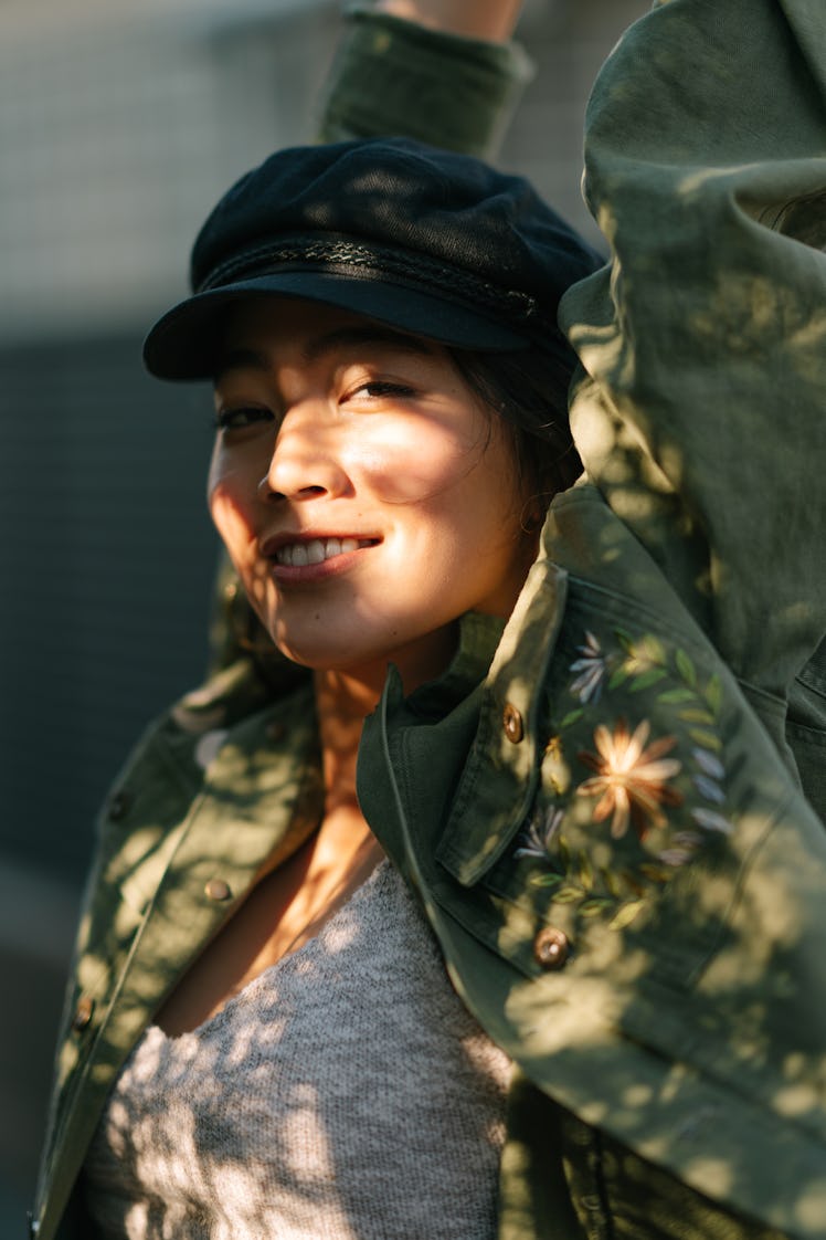 young woman smiles into camera as she thinks about her sept. 4, 2022 weekly horoscope
