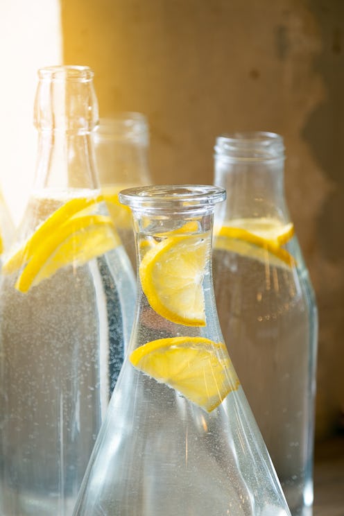 A cold refreshing summer drink or cocktail in a decanter. Cleansing water or lemonade with lemon sli...