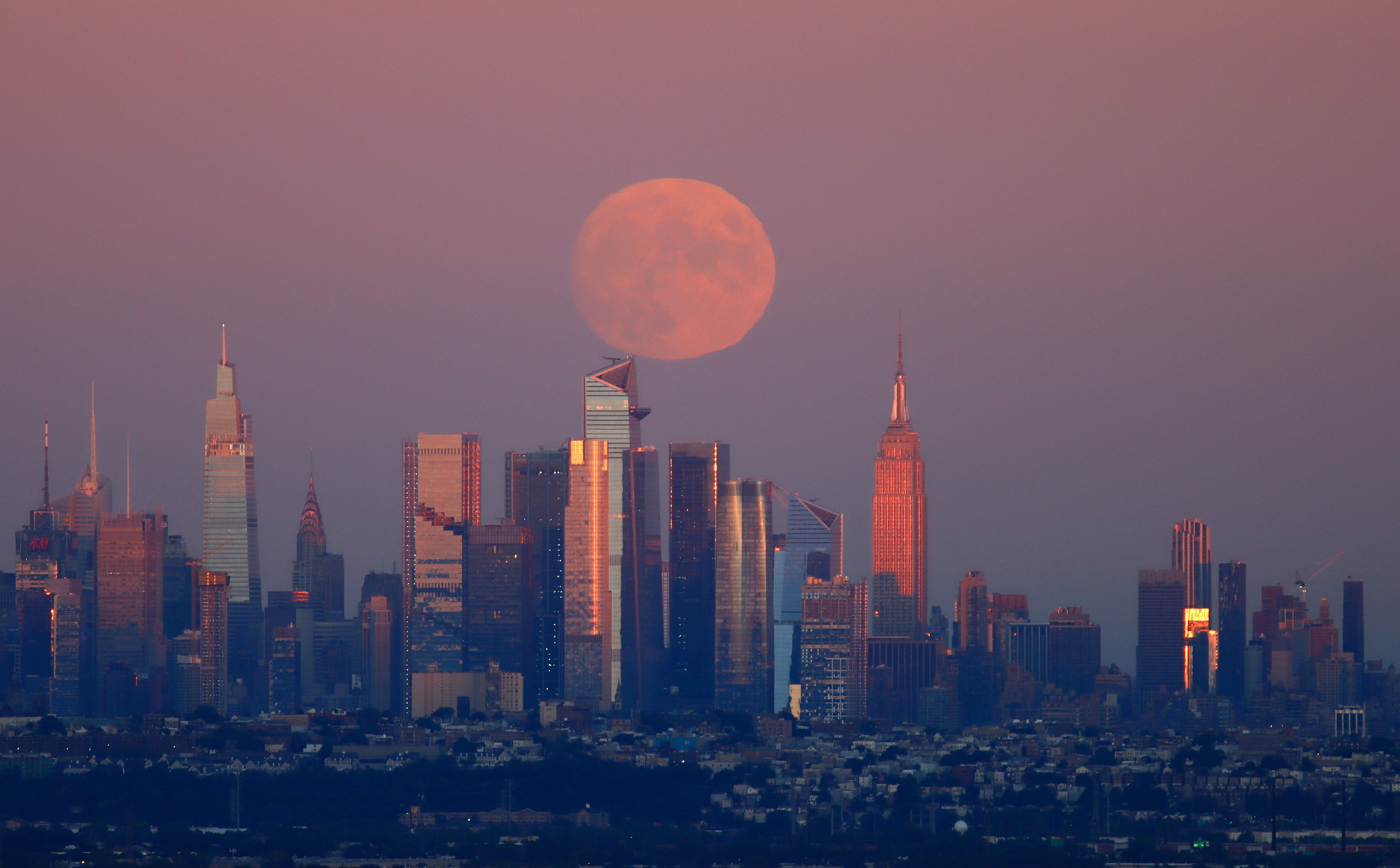 WEST ORANGE, NJ - SEPTEMBER 19: A 98.8 percent Harvest Moon rises behind midtown Manhattan, One Vand...
