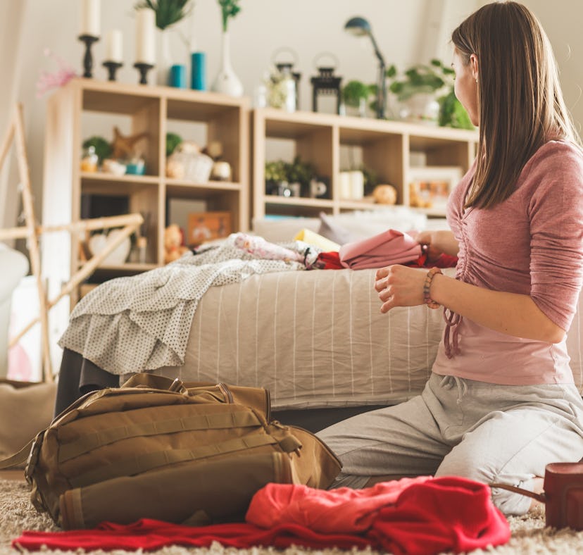 A woman is packing with hacks for traveling with a backpack.