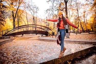 Young beautiful woman enjoys an autumn day