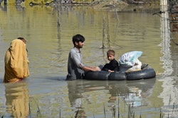 TOPSHOT - A family wades through a flood hit area following heavy monsoon rains in Charsadda distric...