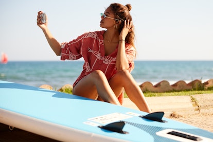 A young woman at the beach using a funny Instagram location