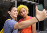 two friends taking a selfie and using a funny Instagram location tag