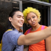 two friends taking a selfie and using a funny Instagram location tag