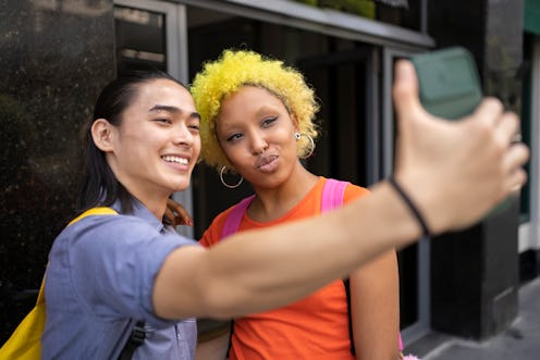 two friends taking a selfie and using a funny Instagram location tag