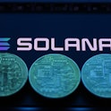 Solana logo displayed on a phone screen and representation of cryptocurrencies are seen in this illu...