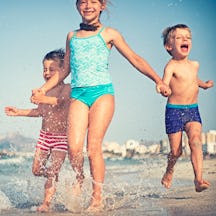 Happy kids running on a beach.