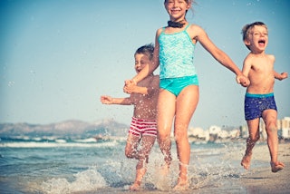 Happy kids running on a beach.