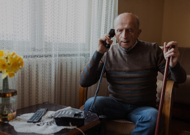 Senior man frowning during his telephone conversation at home