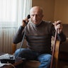 Senior man frowning during his telephone conversation at home