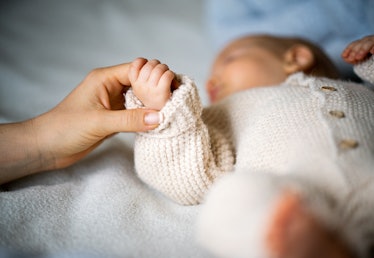 Close-up of mother's hand holding newborn baby's hand