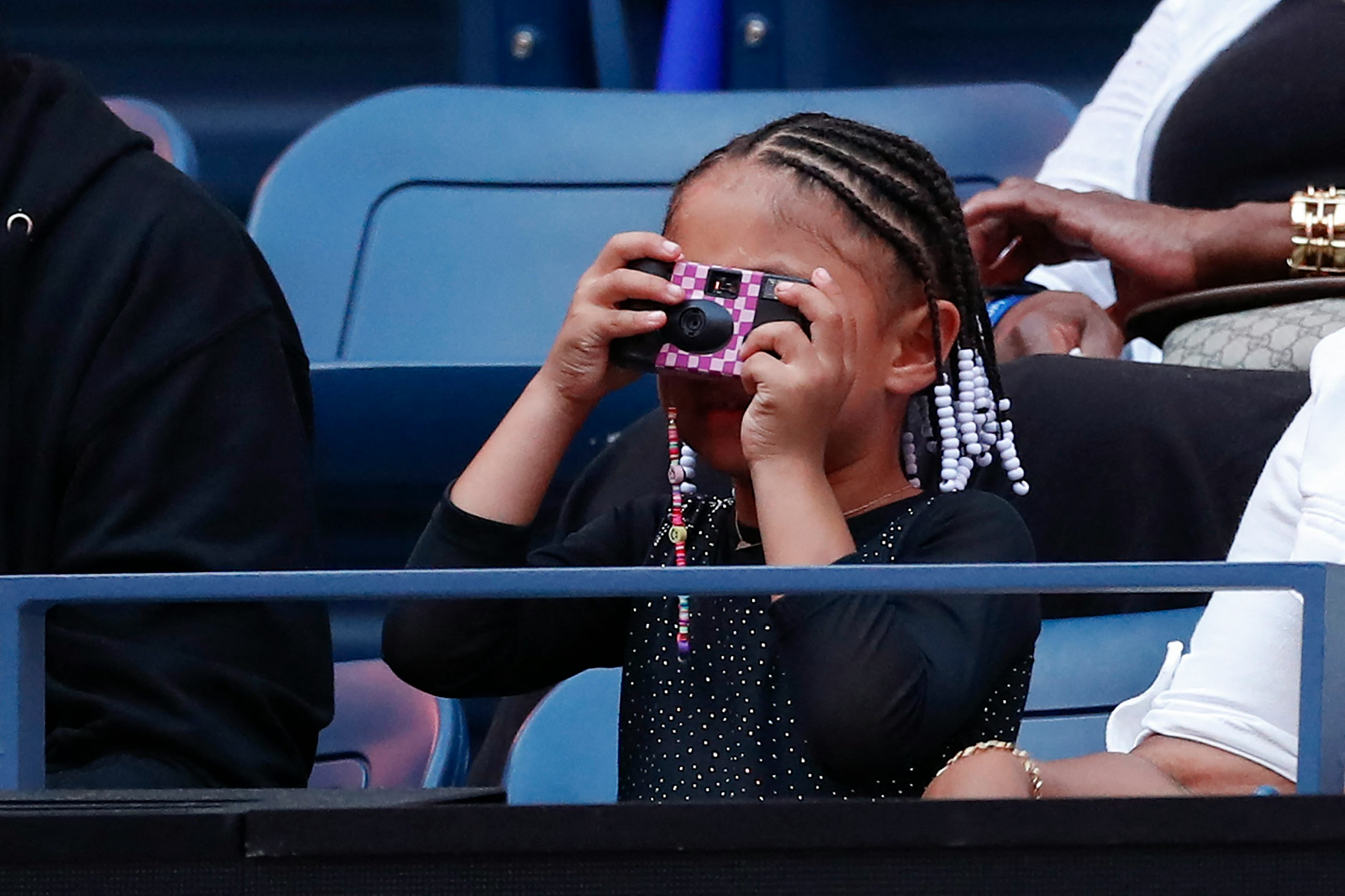 US player Serena Williams' daughter Alexis Olympia takes a picture before her mother plays against M...