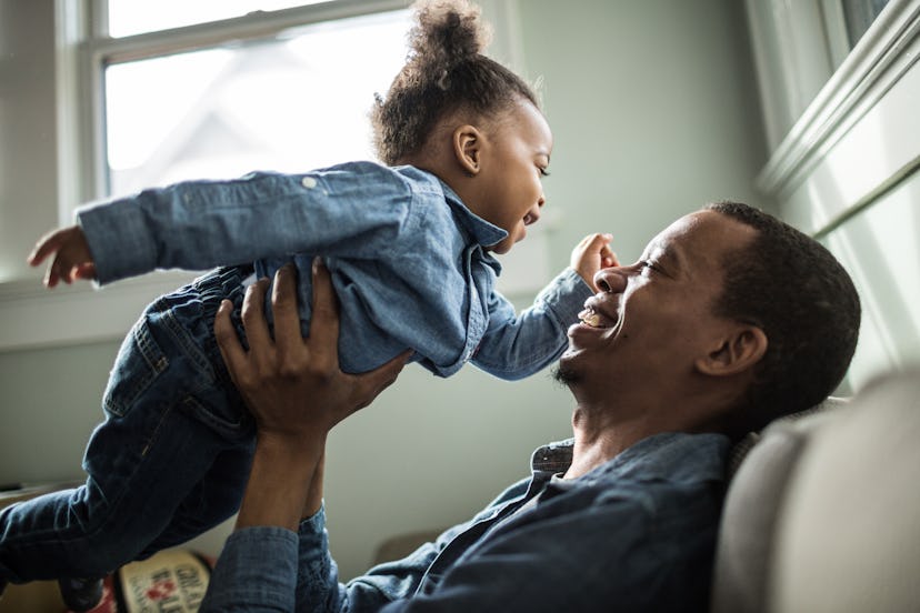 a father lifts up his toddler in a round up of literary girl names