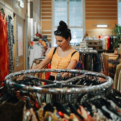 Woman trying out clothes in a second hand shop.