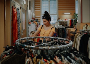 Woman trying out clothes in a second hand shop.