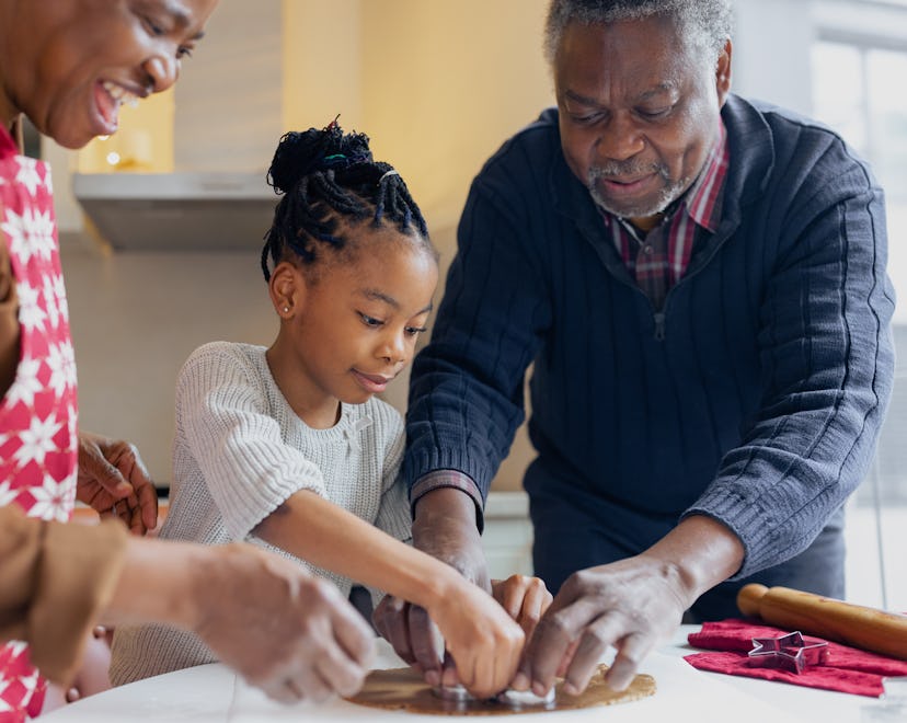 Black grandparents making Christmas gingerbread cookies with granddaughter in an article about grand...
