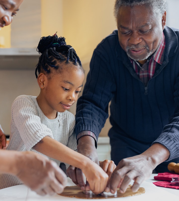 Black grandparents making Christmas gingerbread cookies with granddaughter in an article about grand...