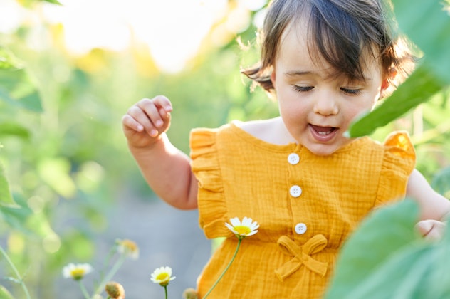 Baby girl playing in the field of sunflowers in a round up of literary girl names
