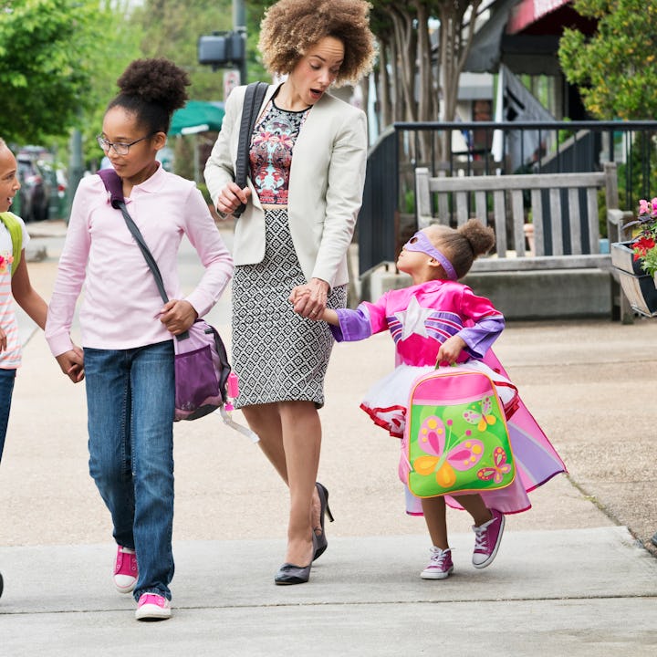 A mom and her three kids walking to school. A new survey found that moms take on a bulk of back to s...