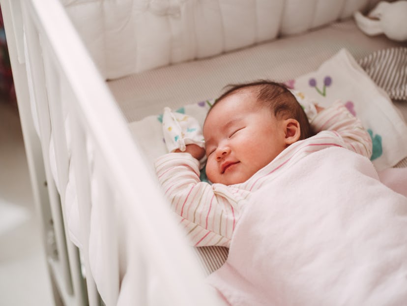 Adorable new born baby smiling sweetly while sleeping soundly in the crib in a round up of literary ...