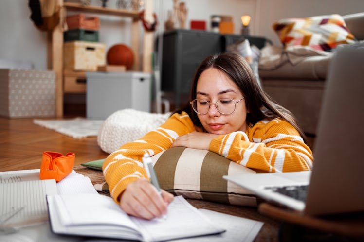 Young woman doing homework to symbolize your sixth house in astrology, which determines how you prio...