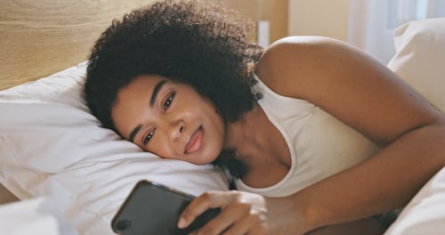 A restless sleeper using her phone in bed.