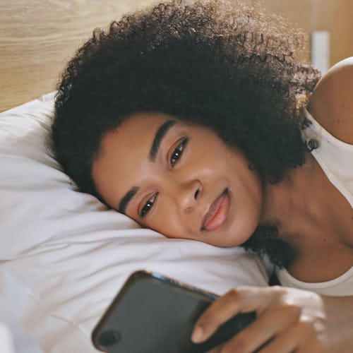 A restless sleeper using her phone in bed.