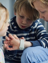 Siblings using a smart watch together