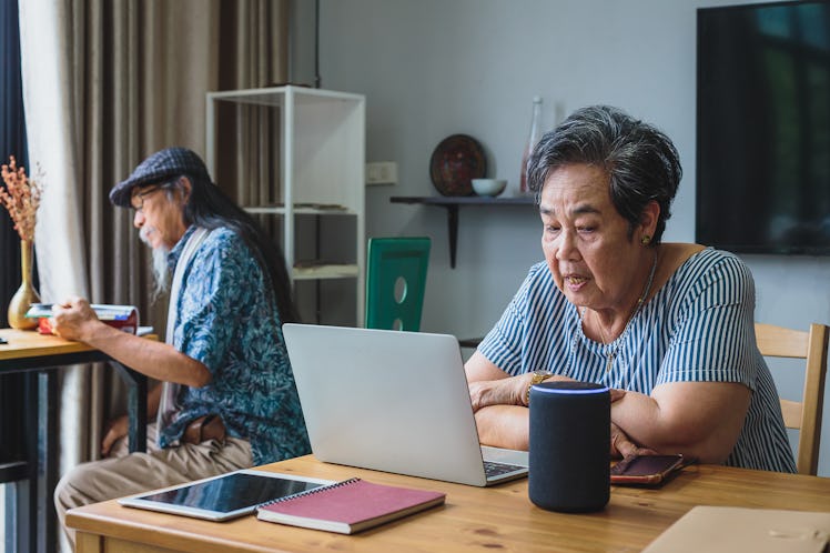 An elderly person using Alexa, which could be used to diagnose cognitive diseases like Alzheimer's.