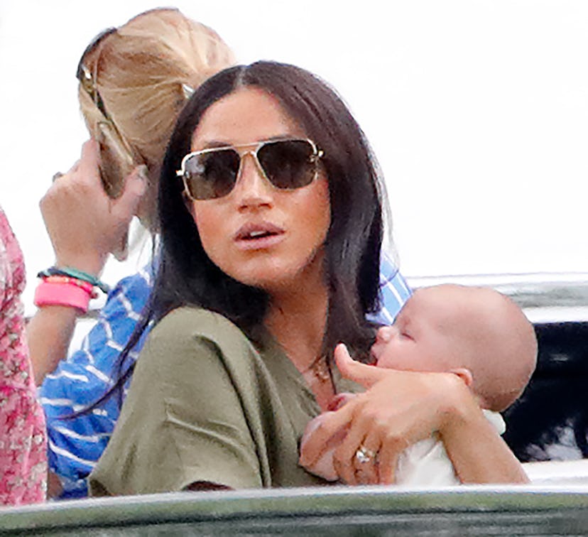 Meghan Markle holds baby son Archie. She and daughter Lilibet are both summer babies.