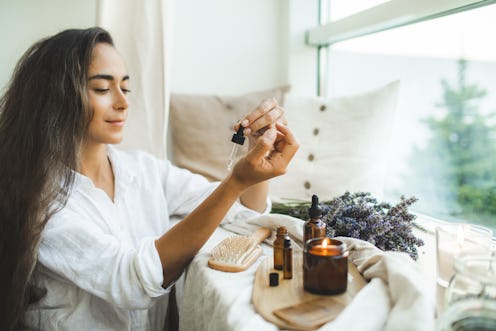 A woman lights a candle as an August 2022 full moon manifestation.