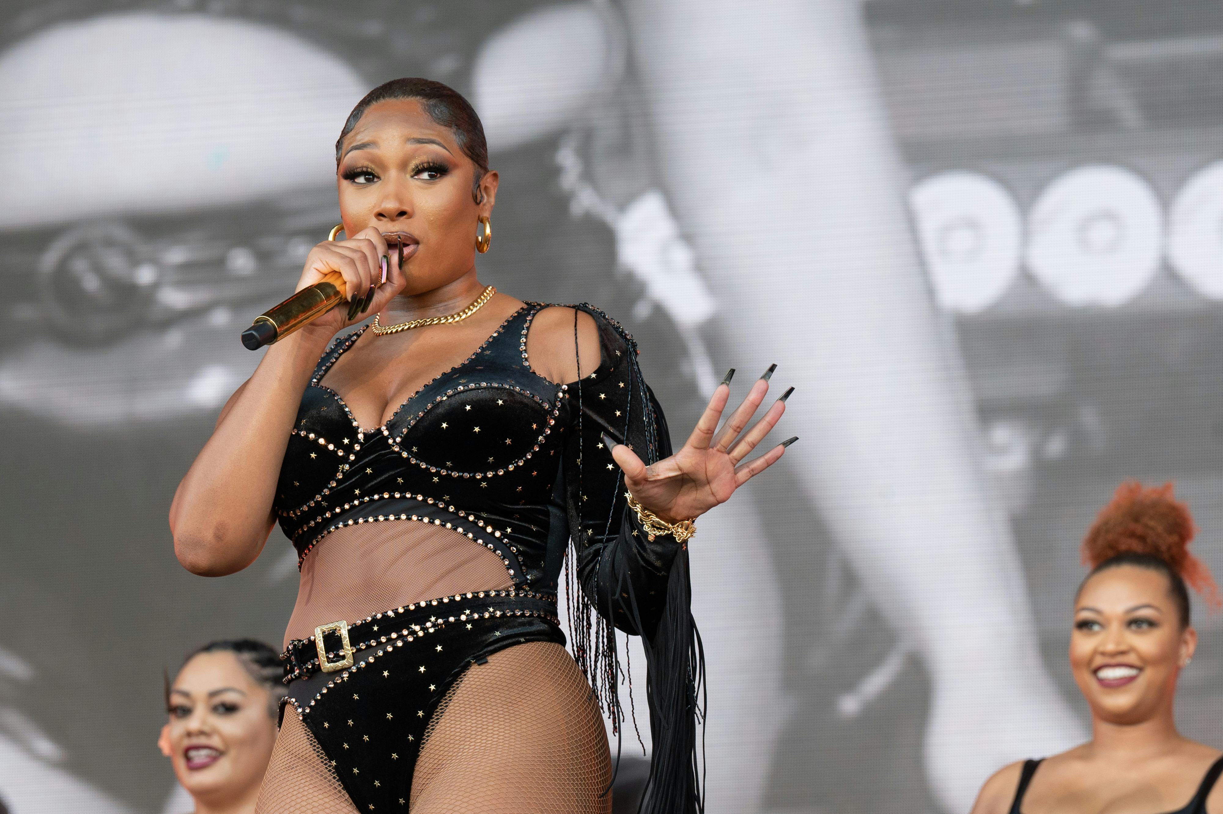 Megan Thee Stallion wearing a black velvet embellished outfit on stage 
