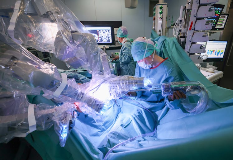 08 February 2022, Schleswig-Holstein, Kiel: A resident (r) and a surgical nurse (l) work during a ro...