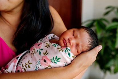 swaddled newborn in an article about how to tell if baby is eating or comfort nursing 
