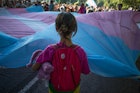 一个小孩面对着变性人骄傲旗