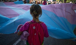 A little kid faces a trans pride flag