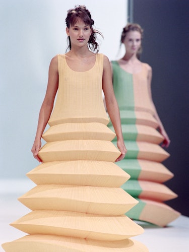 Models display Pleats please dresses with wired hoops as part of Issey Miyake Spring-Summer 1995 rea...