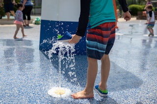 WASHINGTON, D.C.  - MAY 21: Josiah Li, 5, plays in a splash pad at Turkey Thicket Recreation Center ...
