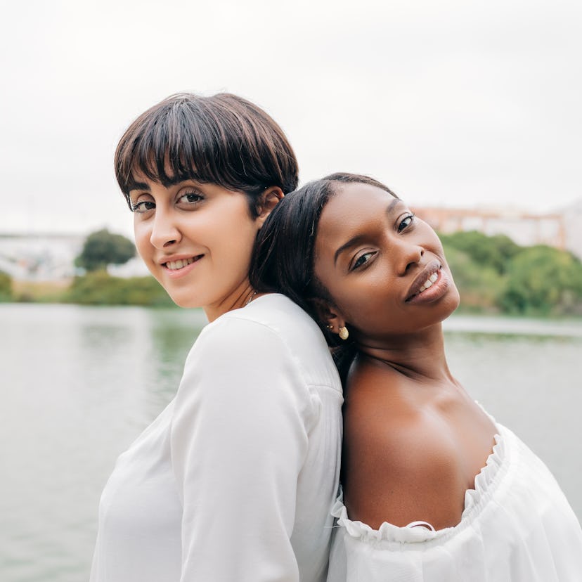 two women pose with their backs to each other as the chat about virgo compatibility with each zodiac...