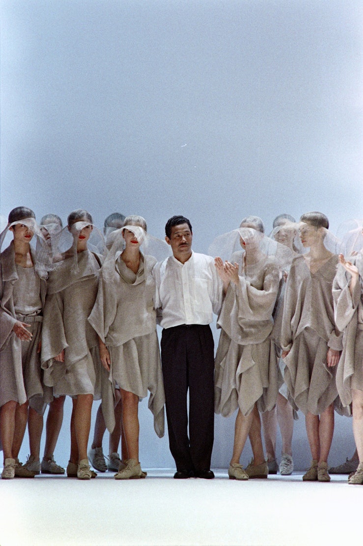 Japanese fashion designer Issey Miyake (C) and his models acknowledge the audience at the end of the...
