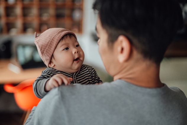 A father shot from behind with his baby over his shoulder looking at each other in a round up of lit...